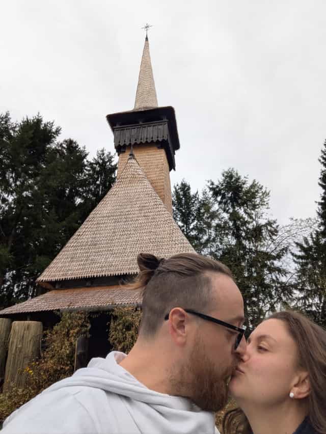 Cécile et Quentin s'embrassent devant une église en bois